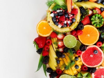 Colorful flat lay of assorted tropical fruits including pineapple, berries, and citrus.